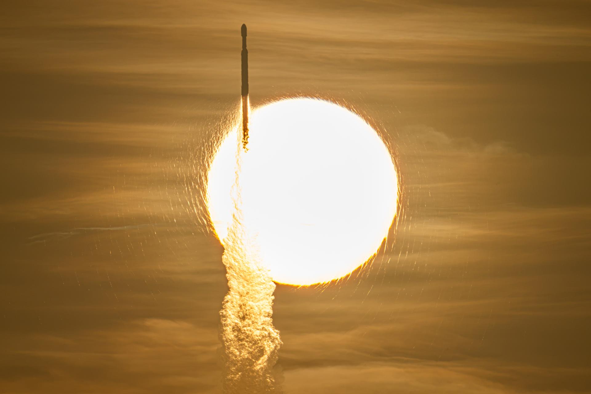 El cohete Falcon Heavy con Roman durante su lanzamiento, delante del disco solar.