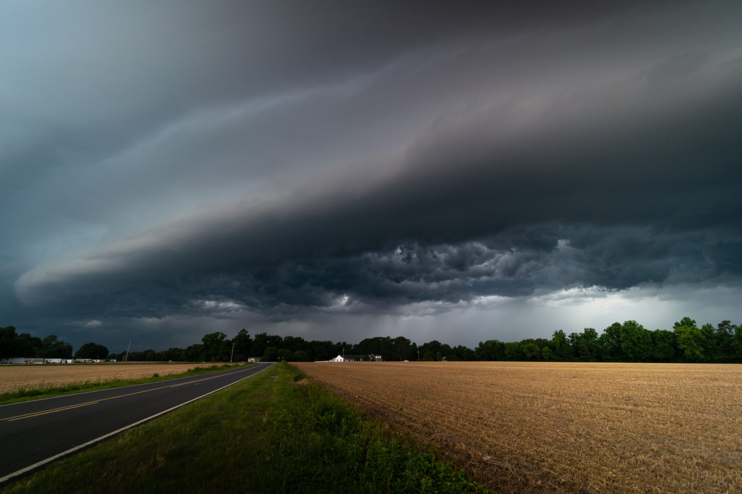 Nubes de tormenta sobre una carretera y campos. Foto de archivo de Lance Stephenson, publicada en Pexels en 2022; no corresponde a Jujuy.